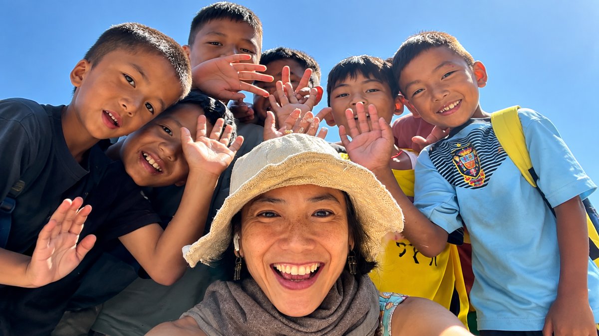 Children and teacher smiling and waving